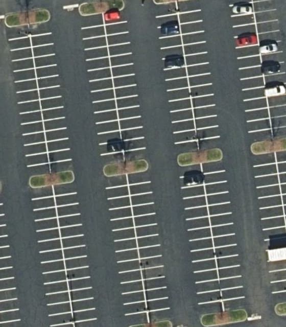 The same ground in February 2023: black pavement with bright white stall lines in redrawn rows.
